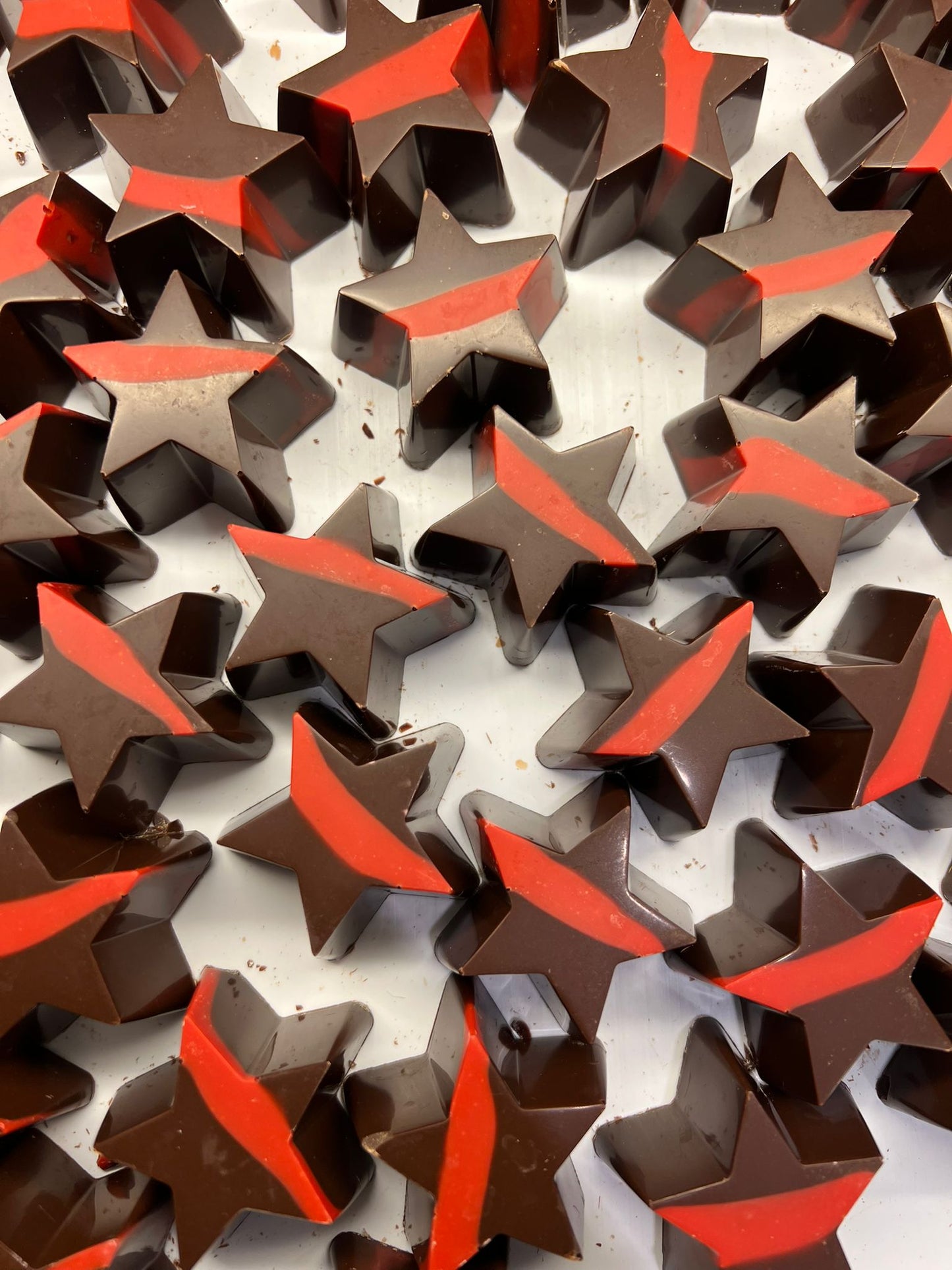 Kerststerren van pure chocolade met rode accenten, 22 gram per stuk, feestelijke chocoladesnack