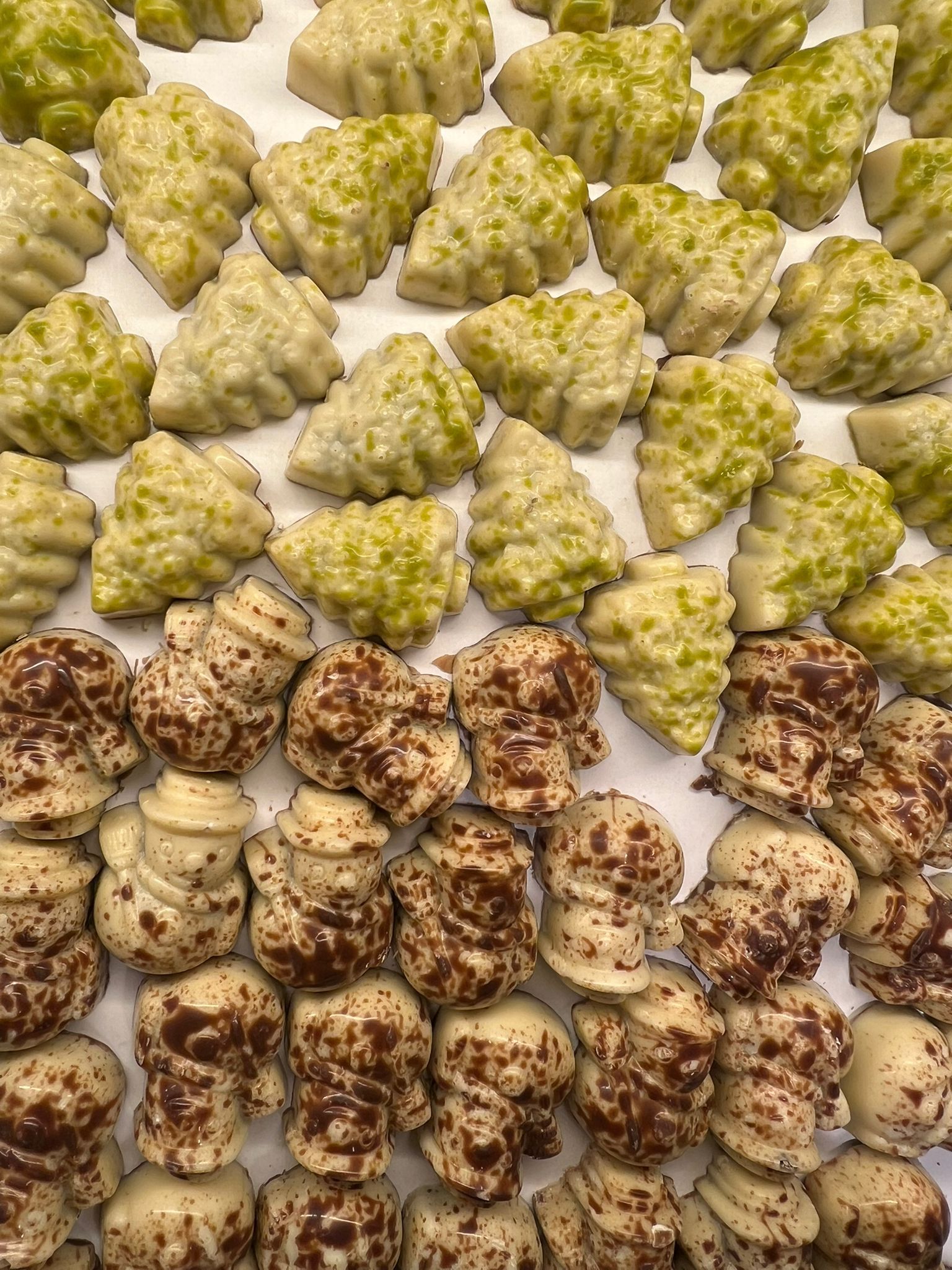 Chocolade sneeuwpopjes en kerstboompjes met pralinévulling, feestelijke winterse chocoladefiguurtjes
