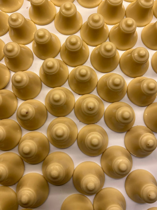 Kerstklokjes van witte chocolade met luchtige slagroomvulling, ambachtelijk gemaakt voor de feestdagen
