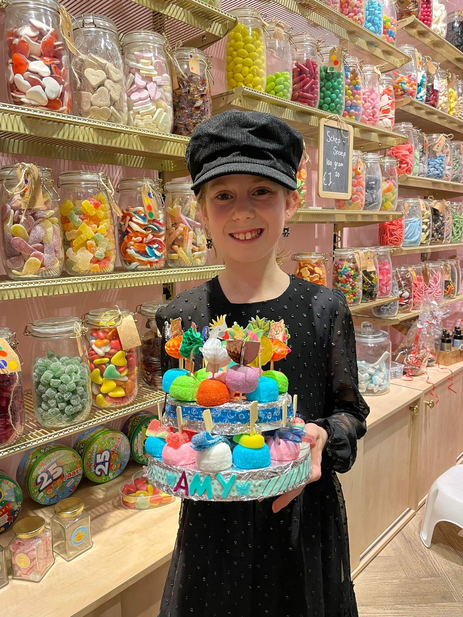 Workshop snoeptaart maken deelnemer toont haar kleurrijke zelfgemaakte snoeptaart